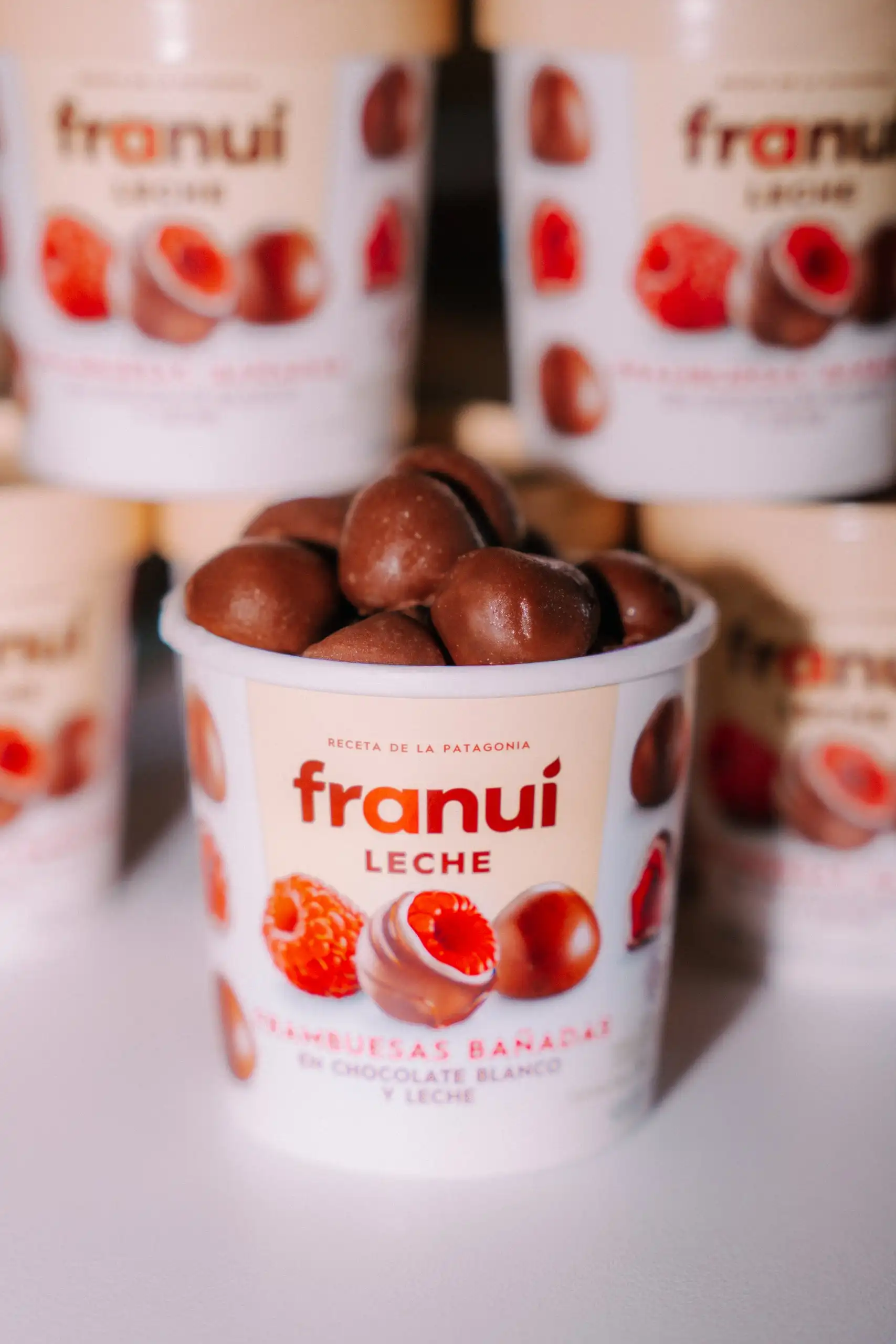 Tarrines de Franuí apilades, amb una en primer pla plena de gerds banyats en xocolata
