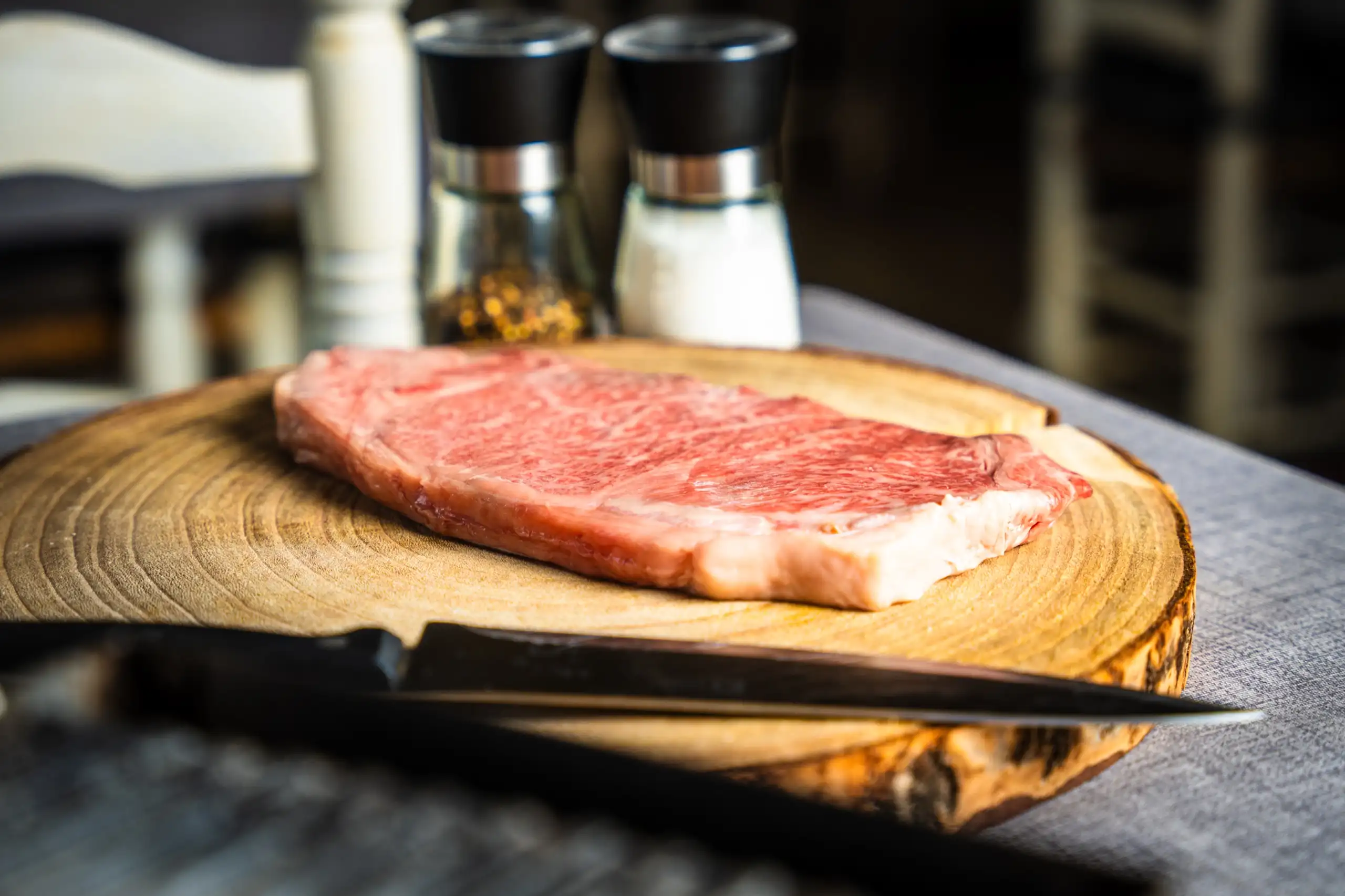 Chuletón crudo sobre tabla de madera antes de pasar por la brasa